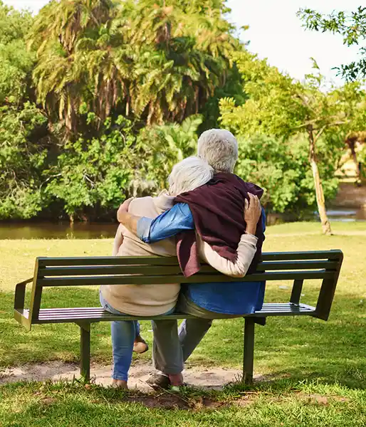 Old Couple sitting on a bench in park 